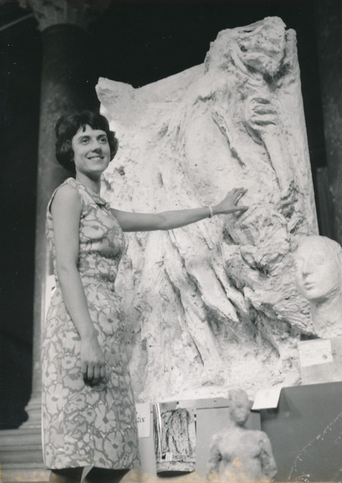 Jacqueline Georges Deyme with her hand on one of her plaster high reliefs